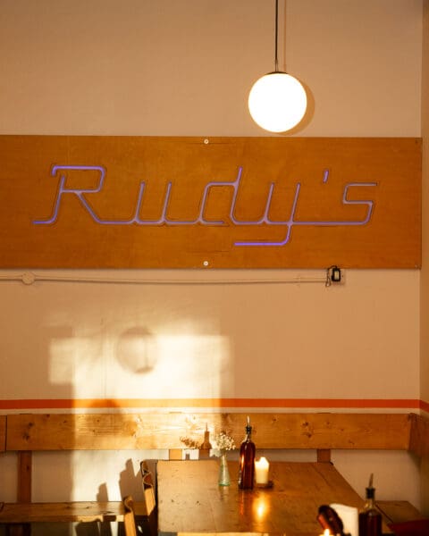 rudy's sign inside restaurant with tables near the wall