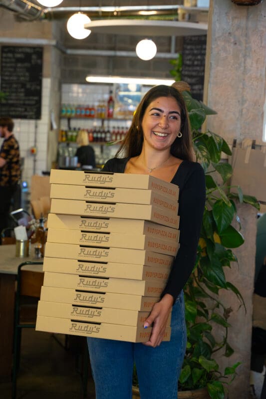person holding rudy's true neapolitan pizza boxes