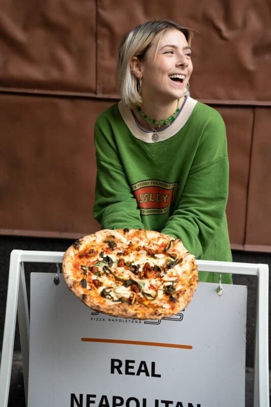person holding neapolitan pizza