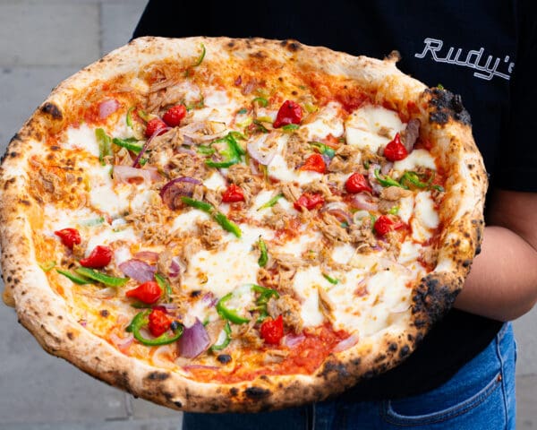 person holding pizza in spitalfields neapolitan pizzeria